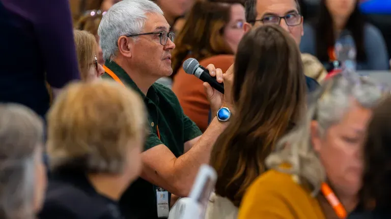 A conference attendee asks a question into a microphone